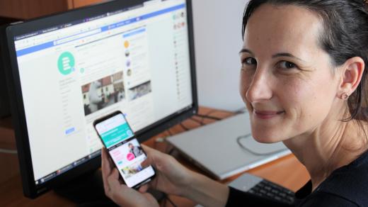 Webeditorka Andrea Poláková ukazuje web Českého rozhlasu na mobilním telefonu a facebookový profil stanice na počítači