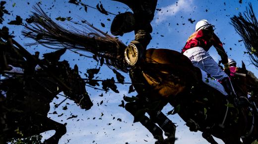 Koně s žokeji překonávají při dostihovém mítinku v Pardubicích (červen 2019). Snímek je součástí sbírky fotografií, se kterými Roman Vondrouš zvítězil v kategorii Fotografický soubor na kongresu Mezinárodní asociace sportovních novinářů v Budapešti