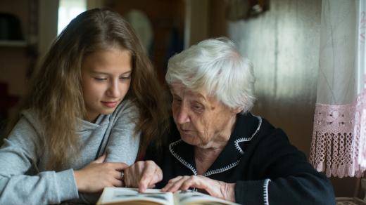 Stará paní čte své vnučce z knihy (ilustrační snímek)