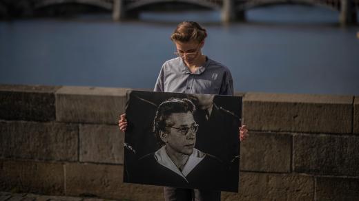 Studentka na Karlově mostě drží portrét Milady Horákové při příležitosti 70. výročí její popravy
