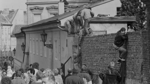 Občané NDR přelézají zeď velvyslanectví NSR (1989)