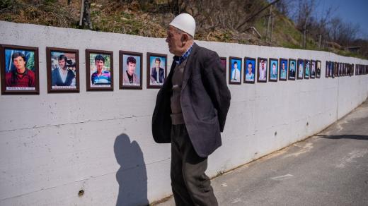 Kosovský Albánec u památníku masakru z války