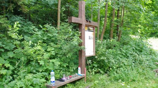 Kříž s lavičkou a popisem patří k naučné stezce po zaniklých obcích Jesenicka