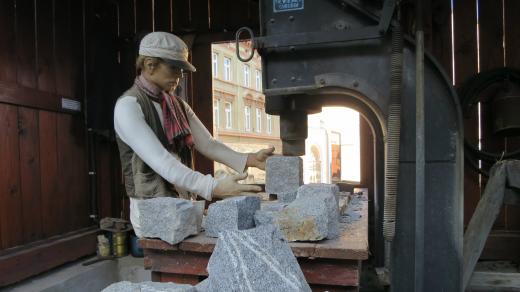 Ukázka práce na historické štípačce kamene ve venkovní expozici skutečského muzea