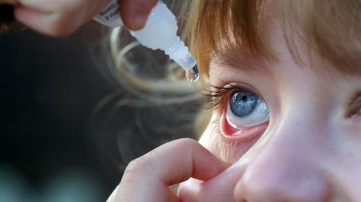 Rodiče vykapávají ditěti oči očními kapkami