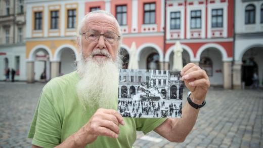Fotograf Václav Toužimský ukazuje svou fotografii tanku bořícího dům