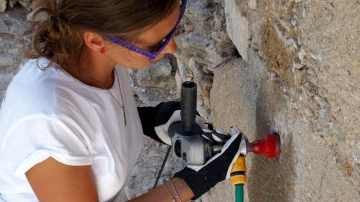 Restaurátorka Dana Macounová odvrtává vzorek pro průzkum stavu podpůrné betonové konstrukce antické fontány