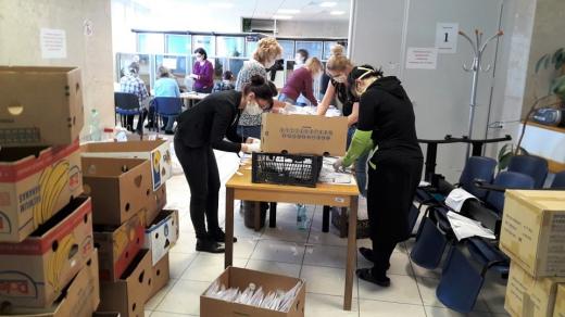 Lidé na městském úřadě v Českém Krumlově kompletují balíčky s rouškami a rukavicemi, které dostane každý obyvatel