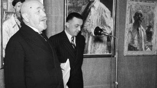Malíř Ludvík Kuba (vlevo) na výstavě svých obrazů v salonu Výtvarné dílo v Praze. 15.4.1943