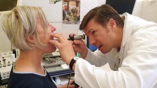 Lékař ORL vyšetřuje pacientce hlasivky