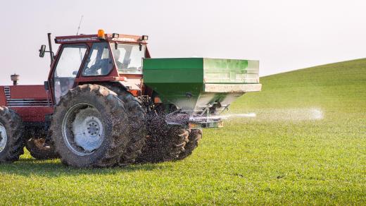 Traktor rozmetá na pole dusíkaté hnojivo