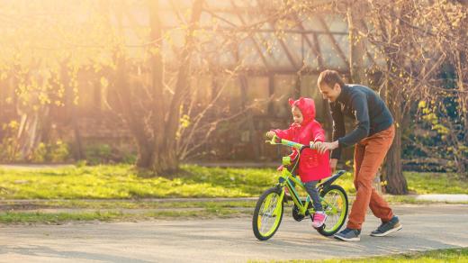 Otec učí dceru jezdit na kole, otec a dcera, rodina, dítě, ilustrační foto