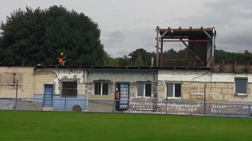 Bourání starých objektů na stadionu v Lounech. Vpravo ční k nebi ještě zbytek staré tribuny, zbytek už je zbouraný
