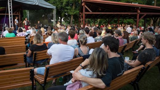 Lidé poslouchají koncert písničkářky Radůzy na festivalu Okolo Třeboně
