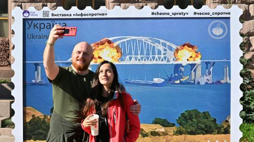 Ukrajinci se fotí před známkou zničeného Kerčského mostu