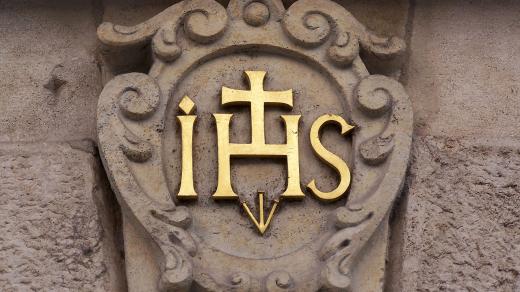 Znak Tovaryšstva Ježíšova – řádu jezuitů na brněnské Staré radnici. Znak obsahuje tzv. christogram IHS, který se v latině vykládal jako zkratka latinské fráze „Iesus Hominum Salvator – Ježíš, spasitel lidí“