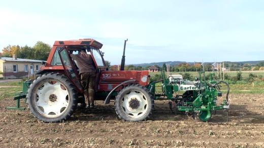 Traktor s robotickou plečkou jahod na poli biofarmy u Temelína