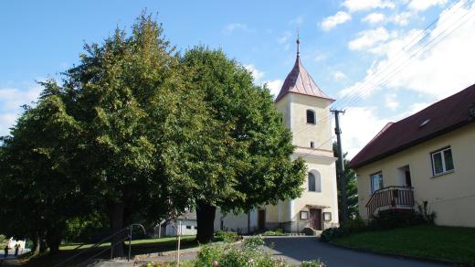 Kostel v obci zakrývá hustá zeleň