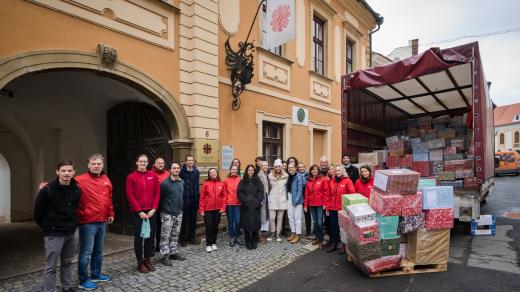 Pracovníci Arcidiecézní charita Olomouc přepravují do kamionu vánoční dárky od dobrovolníků