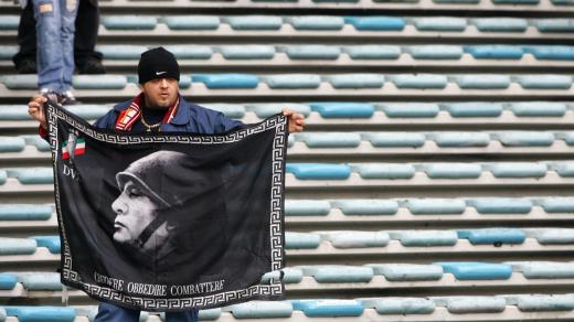 Fanoušek AS Řím držící vlajku s fašistickým diktátorem Benitem Mussolinim