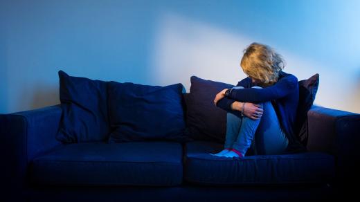 Osamělá žena sedí na pohovce