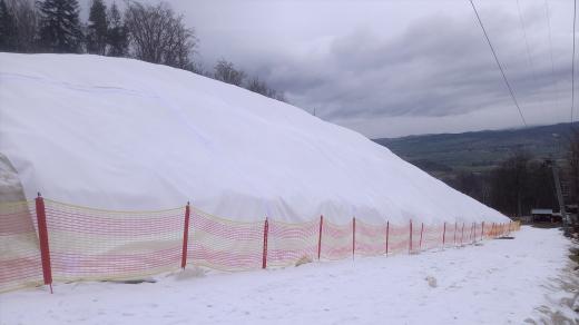 Hromada sněhu pod speciální plachtou ve skiareálu Monínec