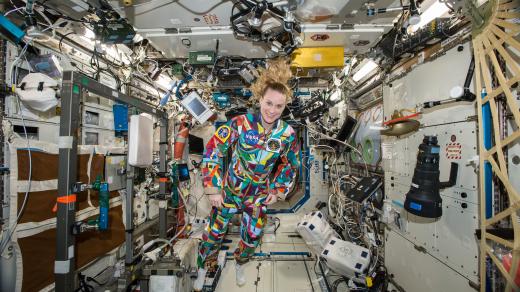 Americká astronautka Kate Rubinsová během svého minulého pobytu na ISS v roce 2016 je oblečená v pracovním overalu, který pomalovali onkologicky nemocné děti z Anderson Cancer Center v Houstonu