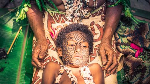 Papua Nová Guinea. S tetováním se zde začíná již v útlém věku. Fotograf zachytil moment, kdy je tetována malá dívka
