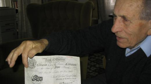 Adolf Burger ukazuje fotokopii jedné z padělaných bankovek