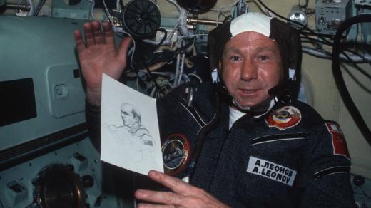 Kosmonaut Alexej Leonov během společné sovětsko-americké mise Sojuz-Apollo v roce 1975 ukazuje svou kresbu velitele Apolla Thomase Stafforda